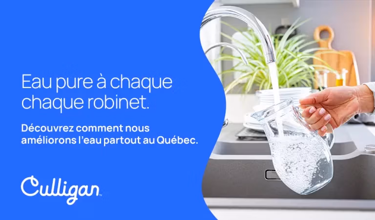 Main d'une femme qui rempli un pichet d'eau au robinet d'eau pure