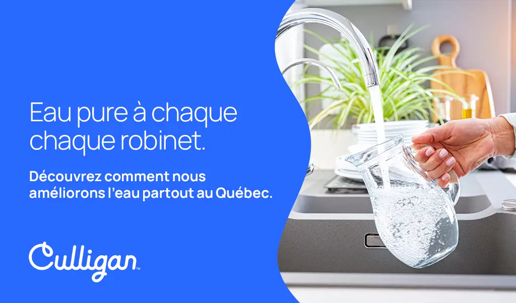 Main d'une femme qui rempli un pichet d'eau au robinet d'eau pure