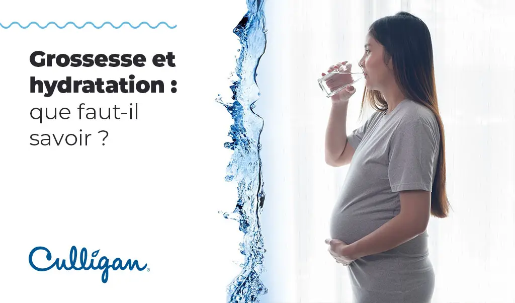Femme en grossesse qui boit un grand verre d'eau
