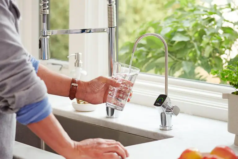 Une personne qui remplie un verre d'eau pure avec le robinet Culligan