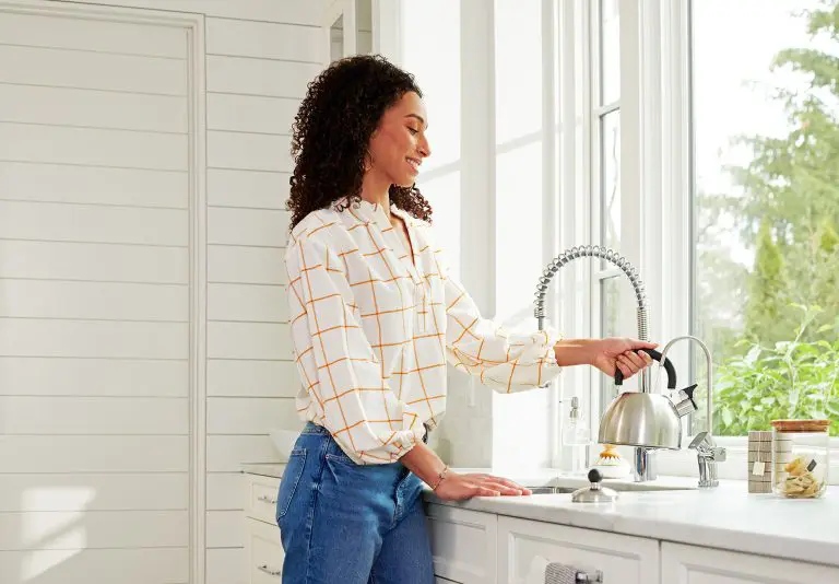 Une femme qui remplie une bouilloire d'eau à l'aide du robinet Culligan
