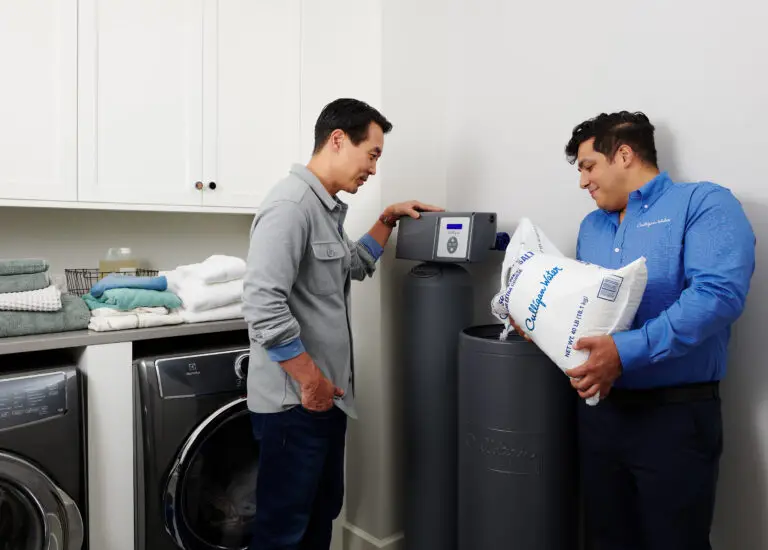 Un professionnel culligan remplie le réservoir de traitement d'eau avec du sel