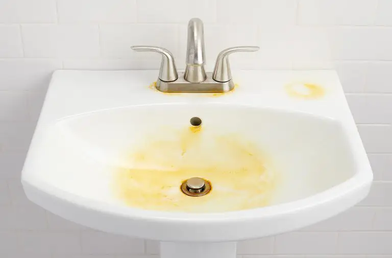 Une évier blanche tâché d'eau rouillé