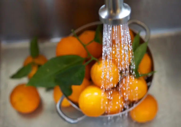 Robinet qui coule pour laver des oranges, la prise de vue est de haut