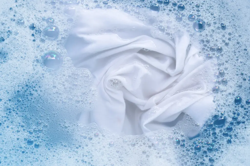 Eau savonneuse qui lave un vêtement blanc