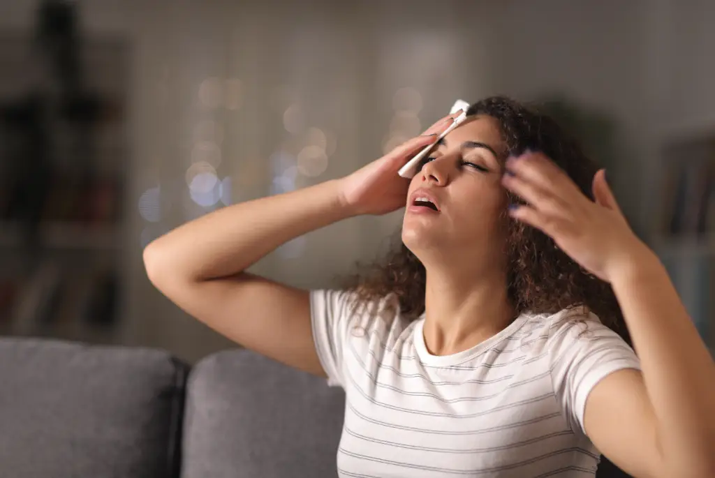 Une femme qui s'éponge le front elle a chaud et doit se s'hydrater