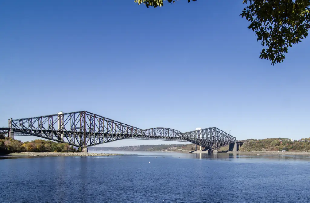 un grand pont en acier qui surplombe un grand étendu d'eau bleue