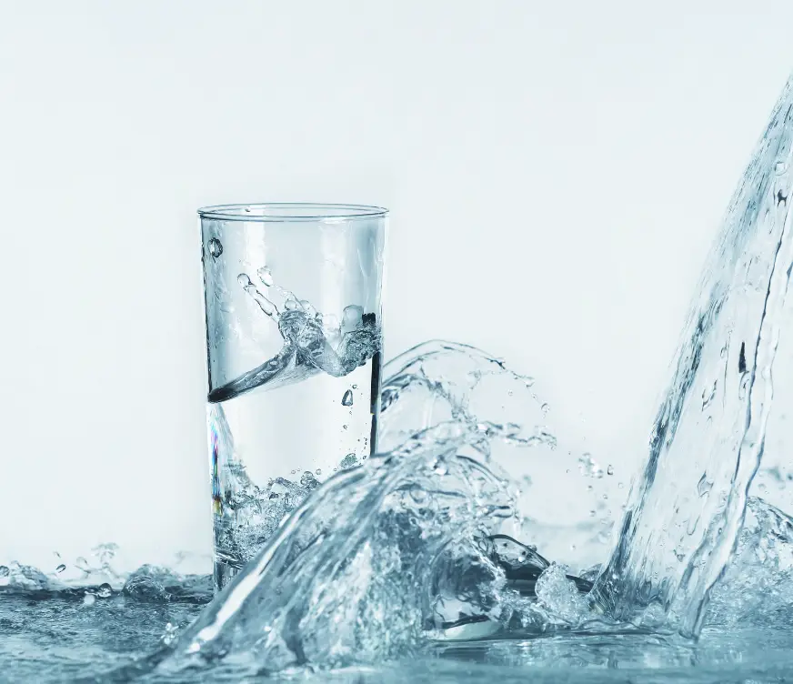 grosse vague d'une eau transparente, elle ricoche sur un verre remplie d'eau