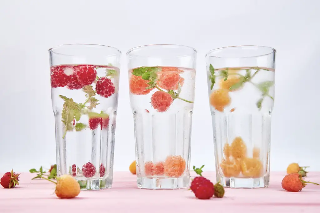Trois verre d'eau clair avec des petits fruits flottants à l'intérieur