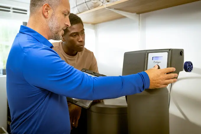 Un professionnel de chez Culligan qui explique le fonctionnement d'un appareil à son client