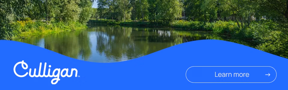 Learn more, Culligan, clean lake, water filtration, serene landscape, water reflection, green trees, blue water, calm lake, en savoir plus, lac propre, filtration d'eau, paysage serein, reflet de l'eau, arbres verts, eau bleue, lac calme,